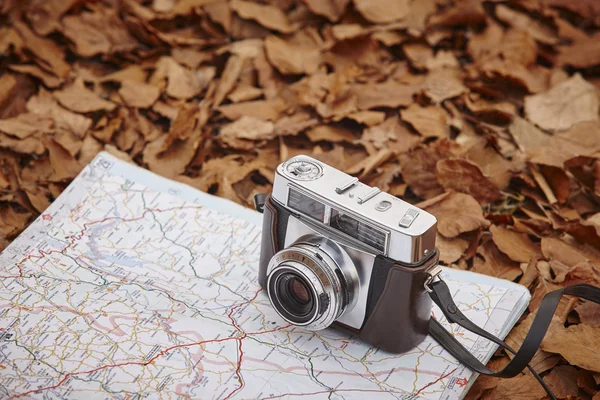 Still life in the autumn forest with camera and map — Stock Photo, Image