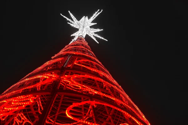 Χριστουγεννιάτικο δέντρο με κόκκινα φώτα και λευκό αστέρι. Σε εξωτερικούς χώρους — Φωτογραφία Αρχείου