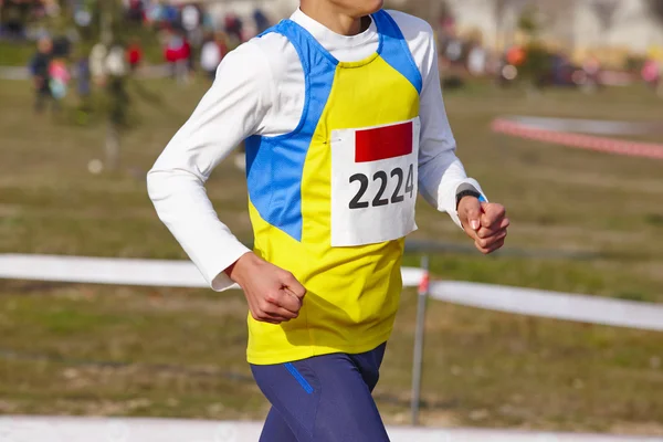 Corredor atlético jovem com número em uma corrida. Circuito exterior — Fotografia de Stock