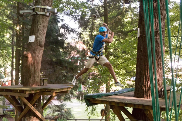 Mann springt beim Klettern im Hochseilgarten — Stockfoto