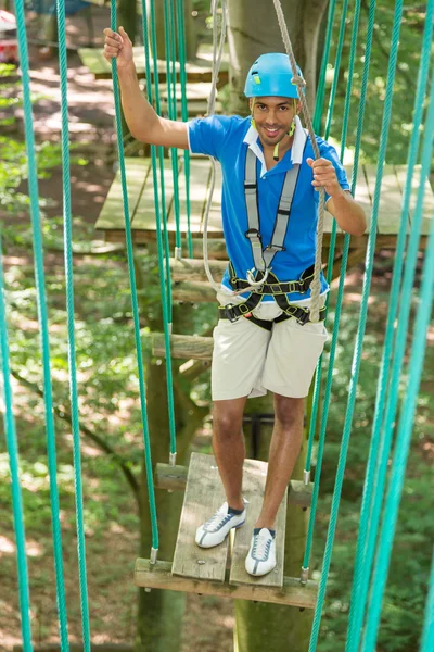 男が高いロープ裁判所で障害物を登る — ストック写真