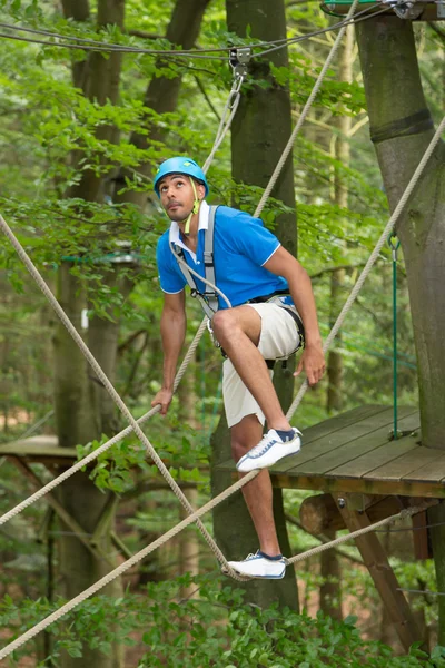 Sportsman está escalando en el curso de cuerda alta — Foto de Stock