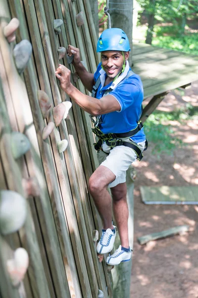 Escalador na parede de escalada em curso de corda alta — Fotografia de Stock