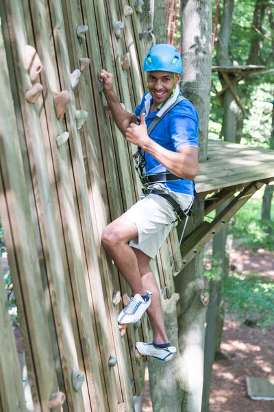 Escalador na parede de escalada em curso de corda alta — Fotografia de Stock