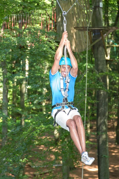 Mann rutscht in Hochseilgarten auf Seilbahn — Stockfoto