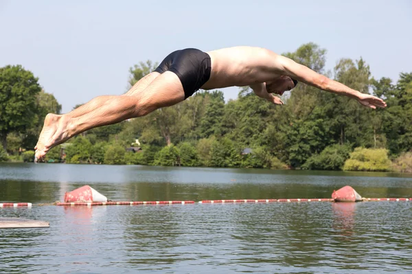 Hombre saltando de trampolín en la piscina —  Fotos de Stock