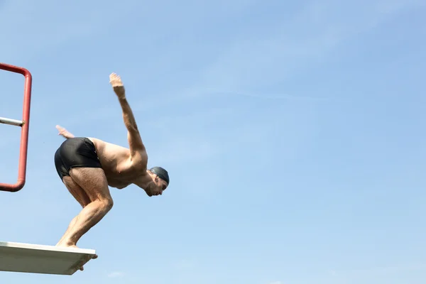 Man jumping off diving board at swimming pool Royalty Free Stock Images