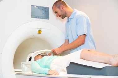 Tıbbi teknik asistan hastanın başına ile MRI tarama hazırlanıyor