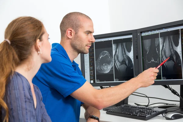 Radiologe berät einen Patienten anhand von Bildern aus der Tomographie oder mri — Stockfoto
