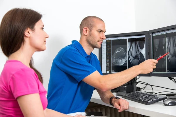 Radioloog councelling een patiënt met afbeeldingen van tomograpy of Mri — Stockfoto