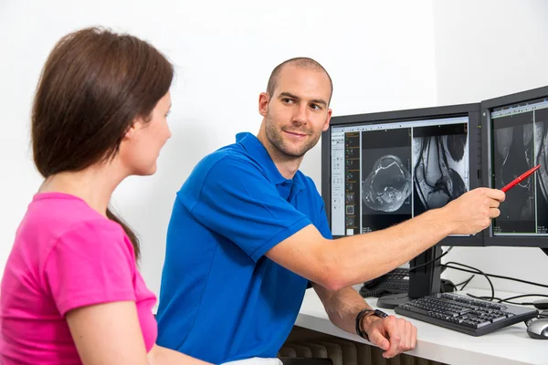Radiologue conseillant un patient à l'aide d'images de tomographie ou d'IRM — Photo