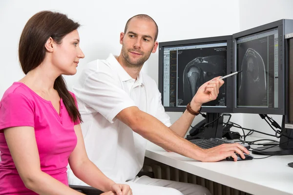 Radiologist councelling a patient using images from tomograpy or MRI — Stock Photo, Image