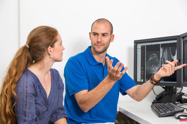 Radiologe berät einen Patienten anhand von Bildern aus der Tomographie oder mri lizenzfreie Stockbilder