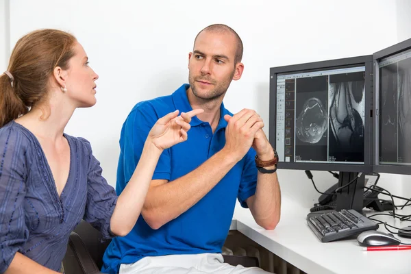 Radiólogo aconsejando a un paciente usando imágenes de tomografía o resonancia magnética Fotos de stock