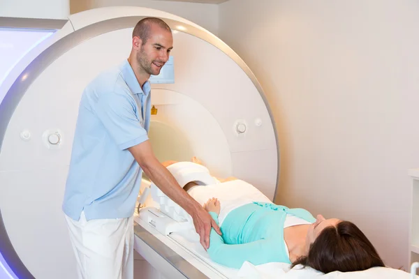 Assistante technique médicale préparant le scan du genou avec IRM Image En Vente