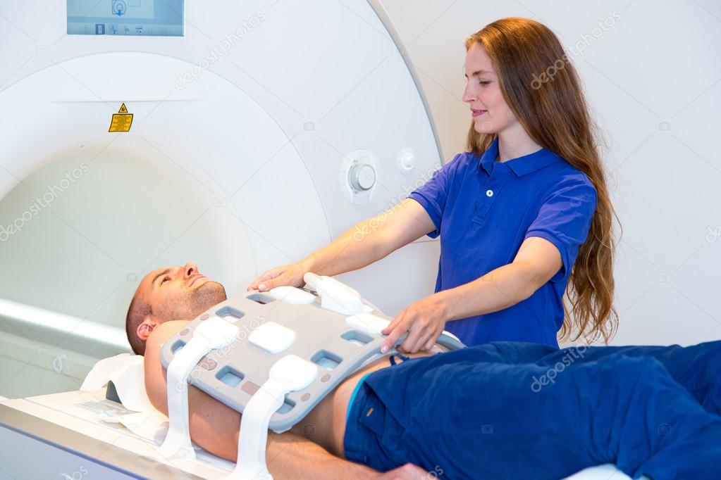 Medical technical assistant preparing scan of torso with MRI