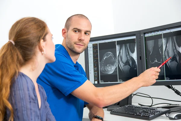 Radiologe berät einen Patienten anhand von Bildern aus der Tomographie oder mri Stockbild