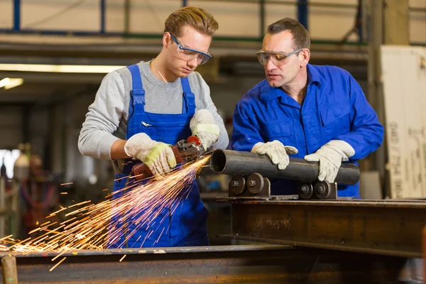 Instructor teaches trainee how to use an angle grinder — Stock Photo, Image