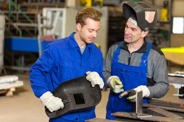 Instructor teaching trainee how to weld metal — Stock Photo, Image