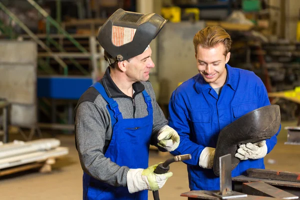 Instructor teaching trainee how to weld metal — Stock Photo, Image