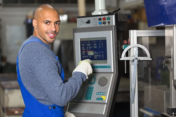 Trabajador operando una máquina con panel de control — Foto de Stock