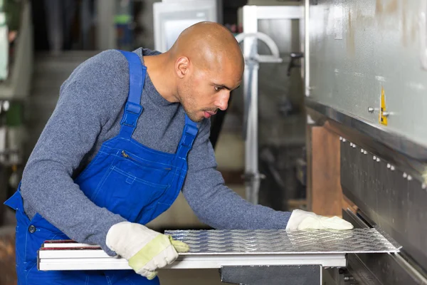 Werknemer die machine voor het buigen van plaatwerk — Stockfoto