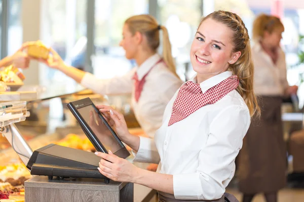 Verkäuferin in Bäckerei arbeitet an Kasse — Stockfoto