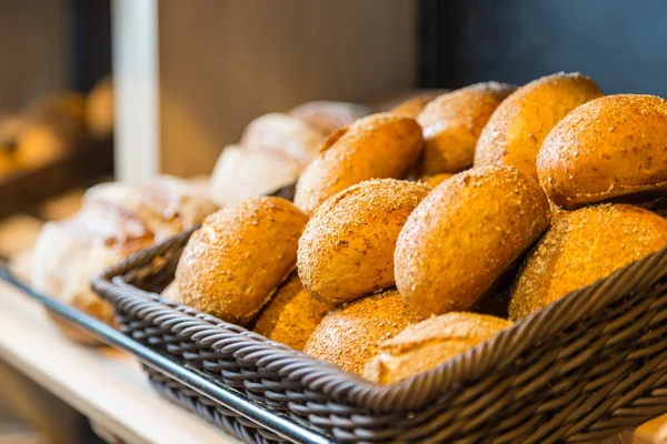 Chleb i bułki na półce w piekarni lub piekarni — Zdjęcie stockowe
