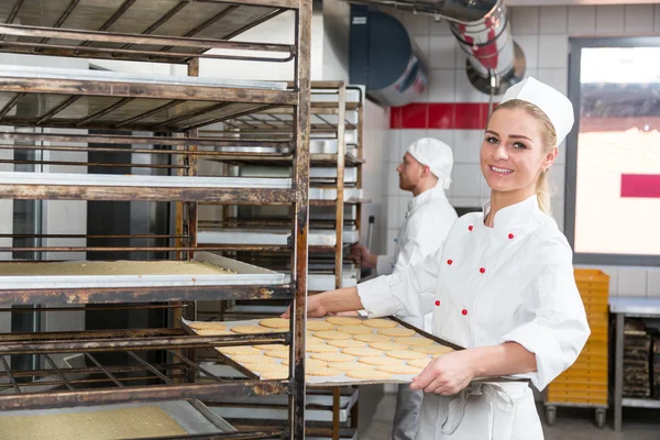 Baker presenteren lade met gebak of deeg in bakkerij — Stockfoto