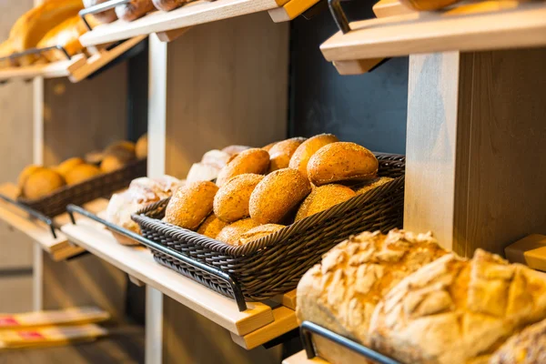 Pan y bollos en estantería en panadería o panadería Imágenes de stock libres de derechos