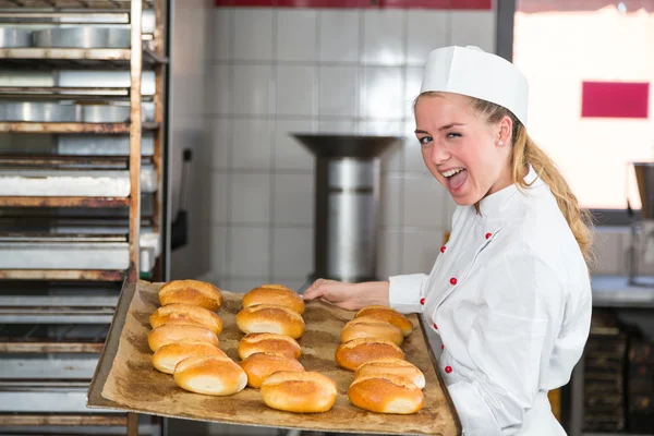 Panettiere in panetteria o panetteria in posa con vassoio di pane fresco Foto Stock