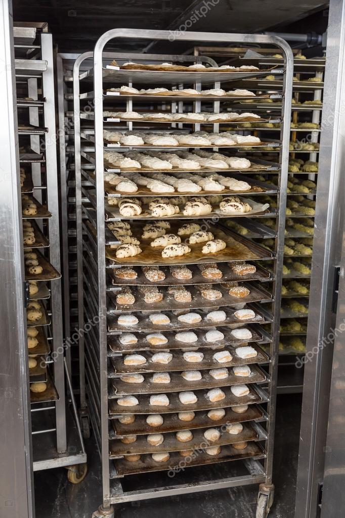 Bakery rack with fresh bread dough in refrigerator Stock Photo by