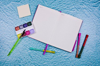 Çizim için albüm, suluboya resimler, fırçalar, mavi arkaplandaki pasteller ve metin için alan. Düz konum. Yüksek kalite fotoğraf