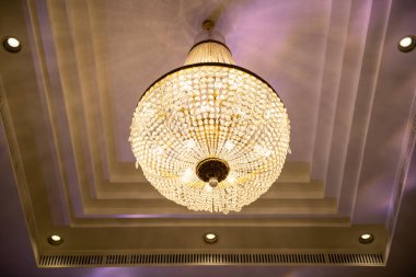 Otel odasının tavanından sarkan kristal avize.