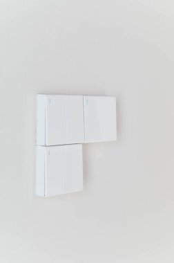 Temiz beyaz duvardaki minimalist beyaz ışık anahtarı modern iç tasarım ev otomasyonu çağdaş stil parlak dikey kompozisyon kopyalama alanı