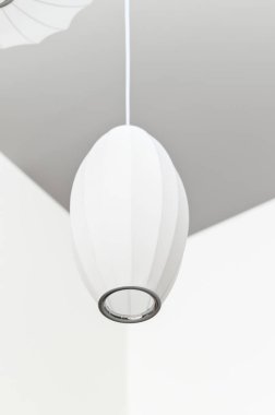 Modern beyaz kolye tavandan sarkan minimalist iç mekan hafif ışıklandırma modern ev dekorasyonu temiz çizgiler zarif tasarım dikey atmosfer yönelimi