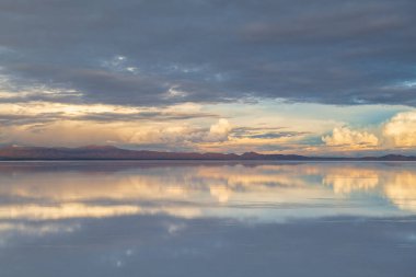 Uyuni Bolivya 'daki sakin tuz düzlüğüne huzur veren gökyüzü yansıması