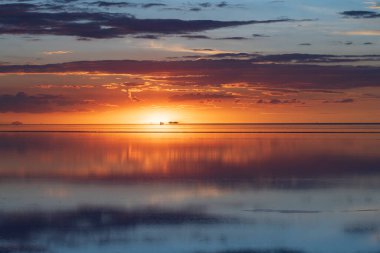 Uyuni Bolivya 'daki tuzlu düz arazi üzerine huzurlu günbatımı yansıması