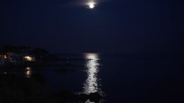 Ay ışığında gece denizi. Geceleri güzel Akdeniz köyü. Deniz kıyısındaki küçük bir kasabanın manzarası. İspanya 'da Calella de Palafrugell' in su ve ışıkları. Costa Brava tatili soğuk. 