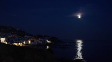 Akşamları güzel Akdeniz köyü. Deniz kıyısındaki küçük bir kasabanın gece manzarası. İspanya 'da Calella de Palafrugell' in su ve ışıkları. Costa Brava tatili soğuk. Kumsaldaki beyaz evler..