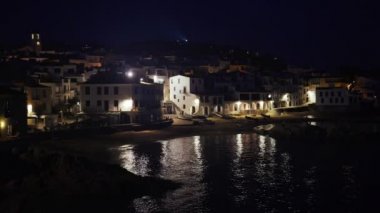 Akşamları güzel Akdeniz köyü. Deniz kıyısındaki küçük bir kasabanın gece manzarası. İspanya 'da Calella de Palafrugell' in su ve ışıkları. Costa Brava tatili soğuk. Kumsaldaki beyaz evler..