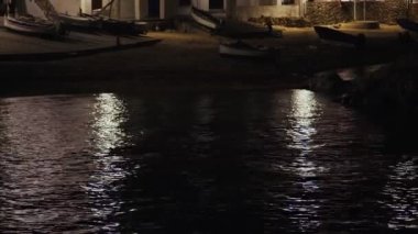 Akşamları güzel Akdeniz köyü. Deniz kıyısındaki küçük bir kasabanın gece manzarası. İspanya 'da Calella de Palafrugell' in su ve ışıkları. Costa Brava tatili soğuk. Sahilde balıkçı tekneleri.