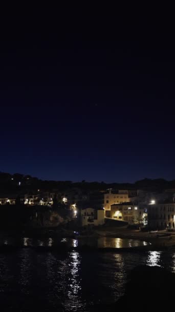 Vertical. Beautiful Mediterranean village at evening. Night views on a small town on a sea coast. Water and lights of Calella de Palafrugell in Spain. Costa Brava vacation an chill. White houses — Stock Video