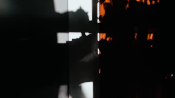 Schaduw van een man die een drankje van een theepot in een beker giet. Silhouet van een man tegen de achtergrond van abstracte chiaroscuro. Abstracte schaduwen van de felle zon. Koffie op een zonnige dag. Theedrinken. — Stockvideo