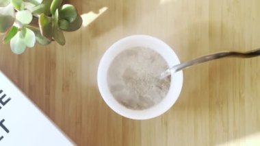 Kahve yapıyorum. Evdeki özel kahve. Barista çaydanlıktan kahve bardağına su döker. Aromatik filtre kahve masada. Seramik beyaz bardak. Kahve molası. Kahvaltıda. Üst görünüm