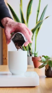 Kahve yapıyorum. Evdeki özel kahve. Barista bir porsiyon kahve çekirdeği ağırlığında. Aromatik filtre kahve masada. Kahve molası. Kahvaltıda. Üst Manzara. Dikey görüntüler