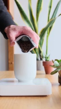 Kahve yapıyorum. Evdeki özel kahve. Barista bir porsiyon kahve çekirdeği ağırlığında. Aromatik filtre kahve masada. Kahve molası. Kahvaltıda. Üst Manzara. Dikey görüntüler