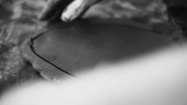 Gros plan des mains féminines qui travaillent avec de l'argile. Potter en train de sculpter. Façonner un produit d'argile. Argile sombre. Vidéo en noir et blanc. Atelier de poterie. L'artiste sculpte à partir d'une masse plastique sombre. — Video