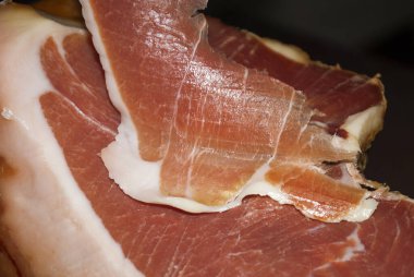 Profesyonel kesici, kurutulmuş İtalyan jambonu dilimleme, İspanya 'dan lezzetli bir ürün. Kuru İspanyol jambonu, Jamon Serrano, Bellota, İtalyan jambonu veya Parma jambonu..