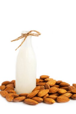 Vejetaryen badem sütü. Badem ve badem sütü şişede. Beyazda izole edilmiş.